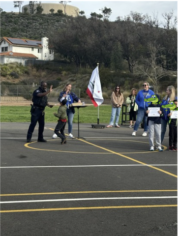 A student giving Officer Kofi a high five at Friday Flag.